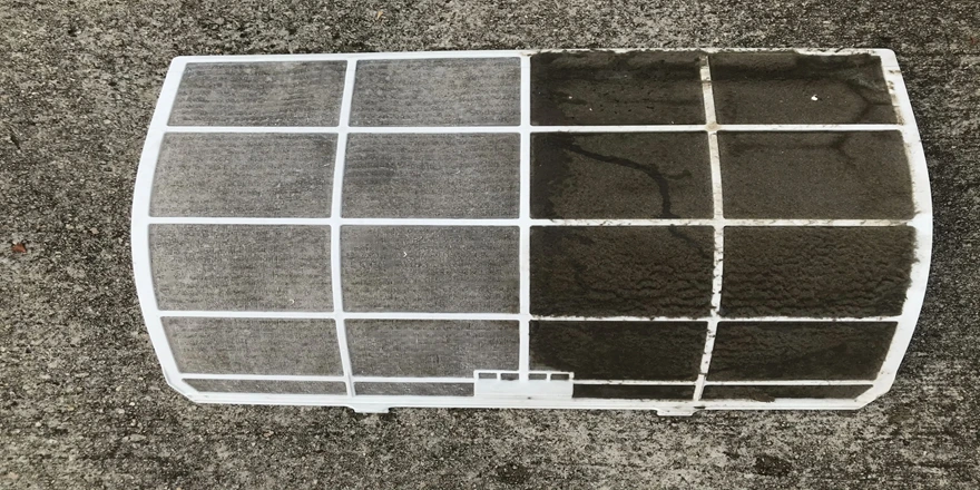 FreshAs Aircon Cleaning - Hand wearing protective gloves spraying cleaning solution into air conditioner unit for thorough maintenance and hygiene